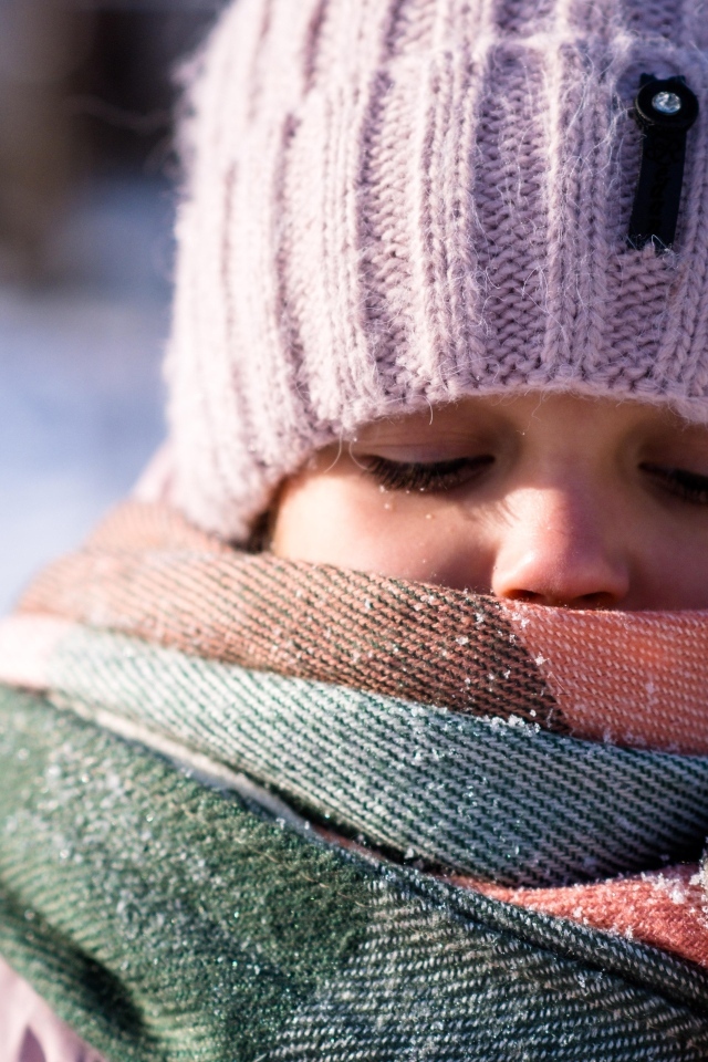 Девочка в теплой вязаной шапке зимой