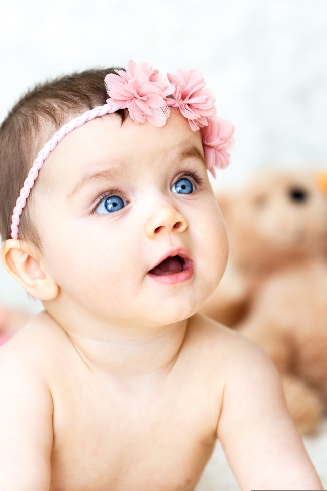 Девочка с голубыми глазами на фоне игрушек