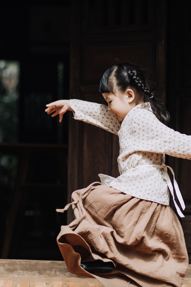 Маленькая девочка азиатка танцует