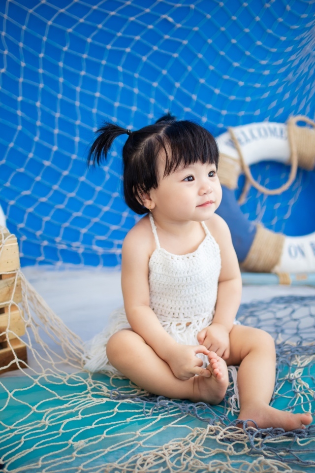 Маленькая девочка азиатка со  спасательным кругом и сетью 