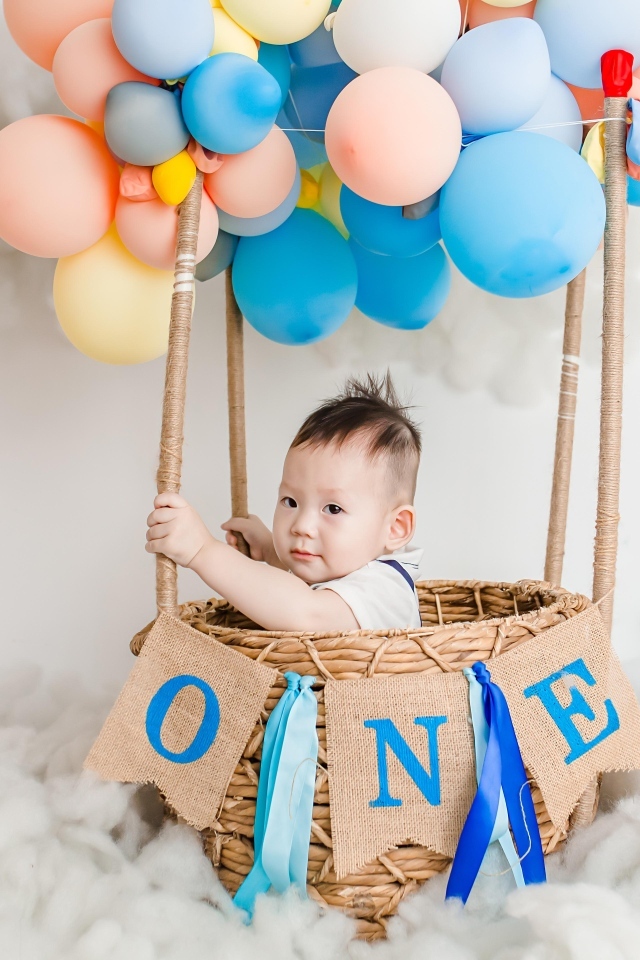 Маленький мальчик в корзине с воздушными шарами