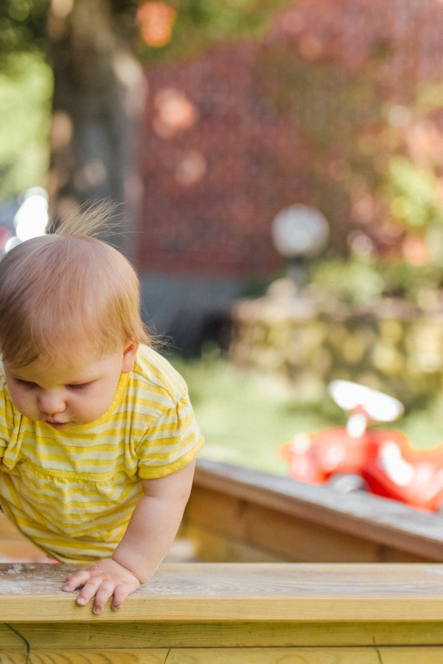 Маленький мальчик играет в песочнице