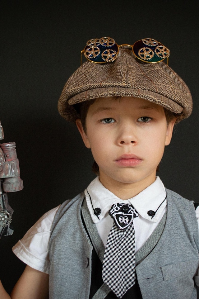 Маленький мальчик с игрушечным пистолетом на черном фоне