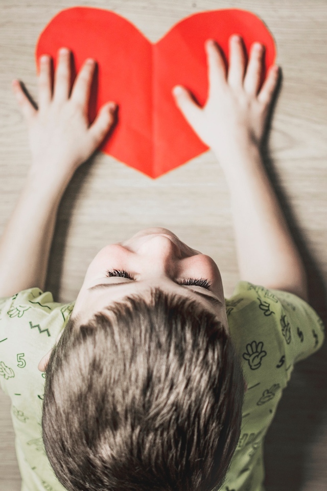 Маленький ребенок с красным сердцем