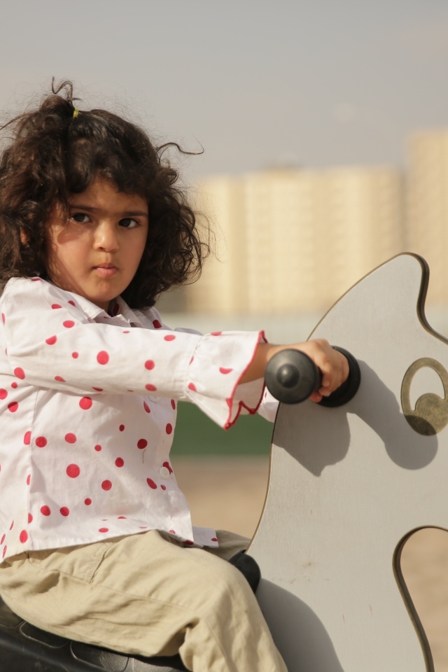 Маленькая девочка на деревянной лошади