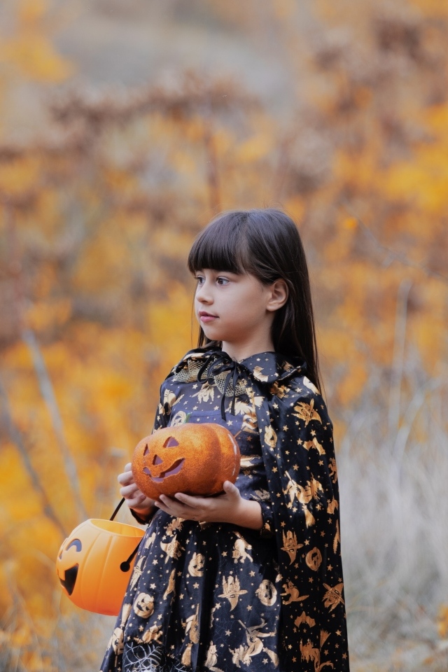 Маленькая девочка с тыквой в руках