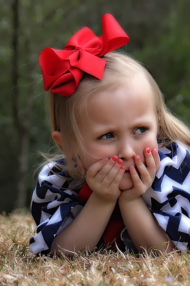 Маленькая девочка с красным бантом на голове