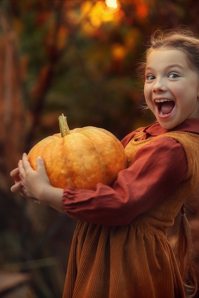 Маленькая рыжеволосая девочка с тыквой