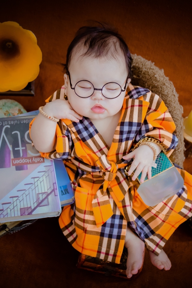 Маленький спящий ребенок в очках и халате