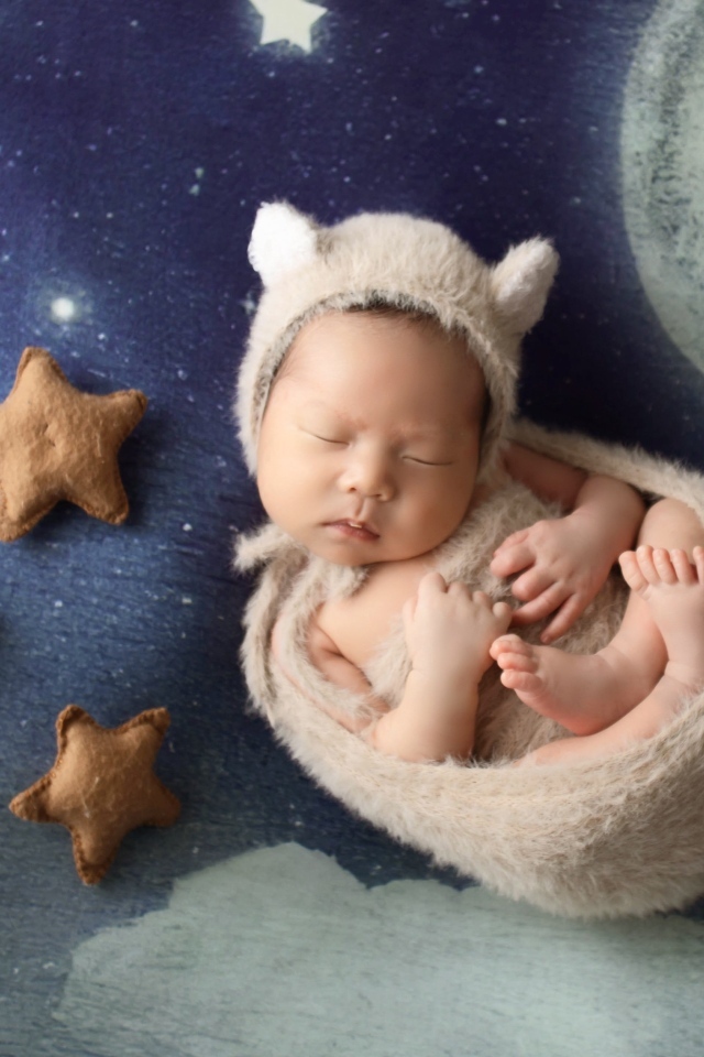 Маленький спящий грудной ребенок на синем покрывале