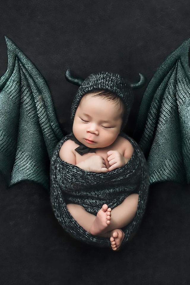 Маленький спящий ребенок с крыльями на Хэллоуин