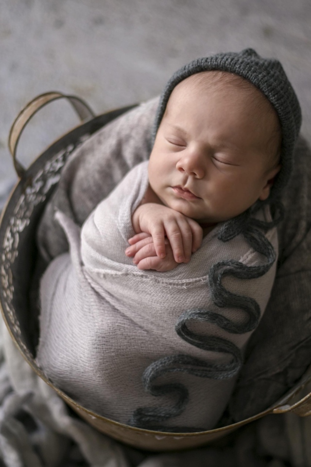 Маленький спящий новорожденный малыш в корзине