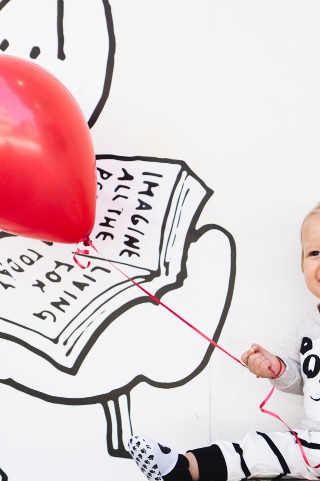 Маленький улыбающийся мальчик с шариком в руках