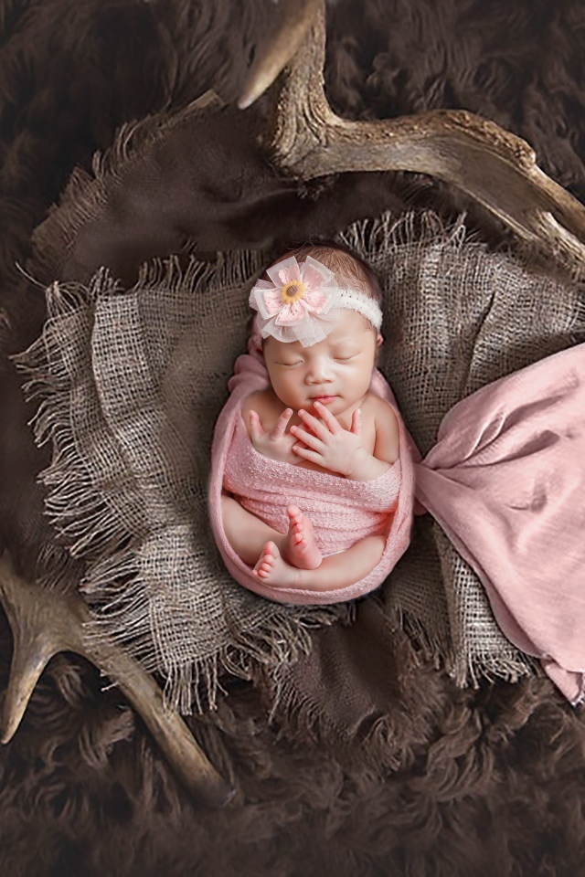 Новорожденная девочка на покрывале с рогами