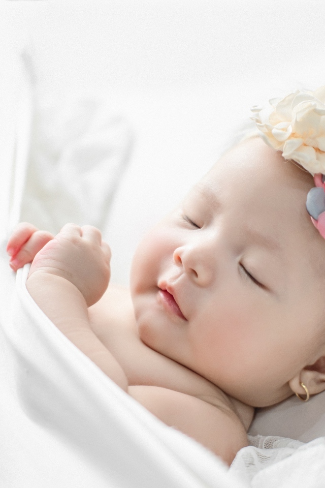 Новорожденная девочка с повязкой на голове