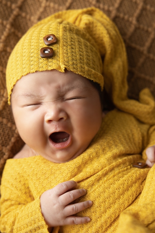 Новорожденный ребенок зевает во сне