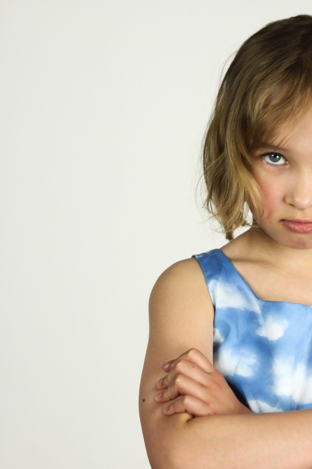 Серьезная девочка на сером фоне