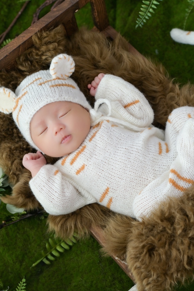 Спящий новорожденный ребенок в костюме тигренка