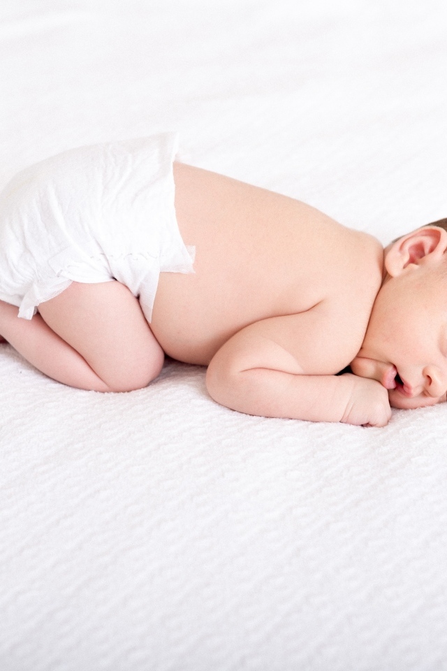 Спящий новорожденный ребенок в памперсе