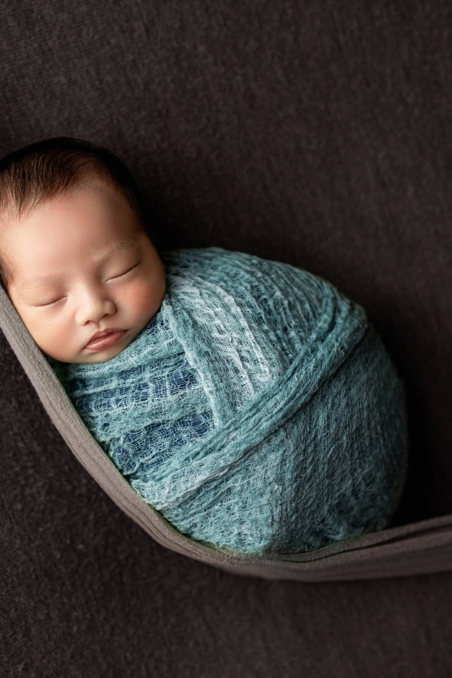 Маленький спящий ребенок завернут в покрывало