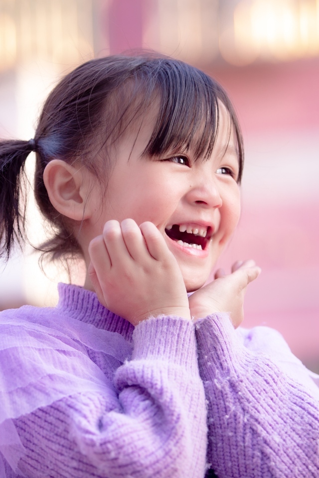Улыбающаяся маленькая девочка азиатка в свитере