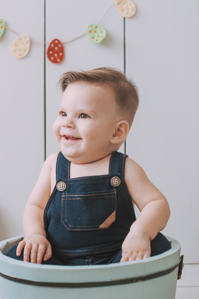 Улыбающийся ребенок сидит в ведре 