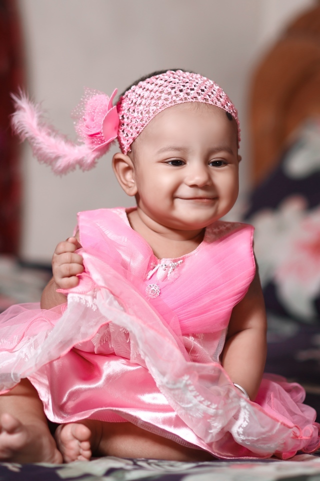 Улыбающаяся девочка в красивом розовом платье