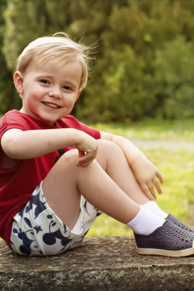 Улыбающийся маленький мальчик в красной футболке