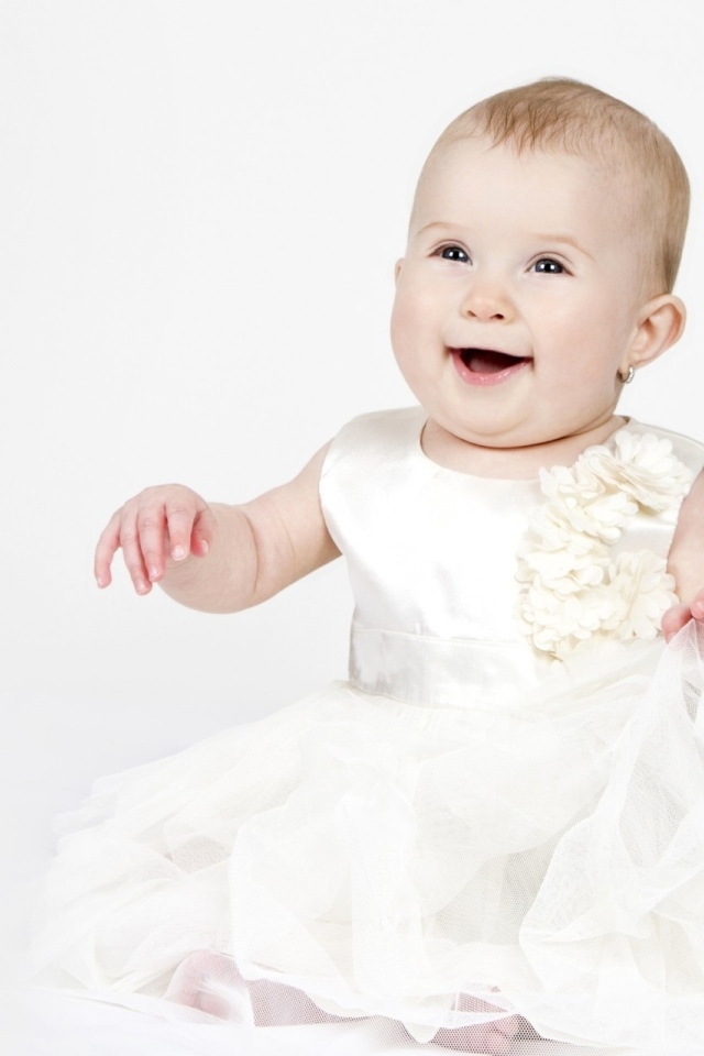 Улыбающаяся маленькая девочка в белом платье 