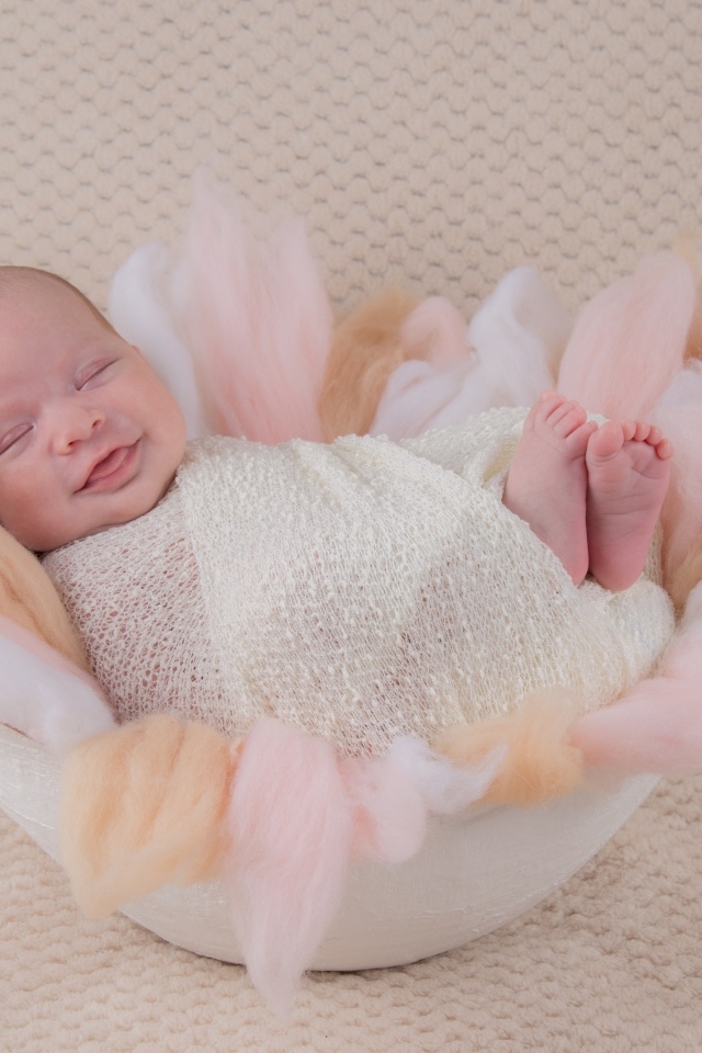 Улыбающийся спящий новорожденный малыш