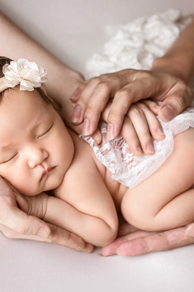 Руки родителей оберегают спящего малыша