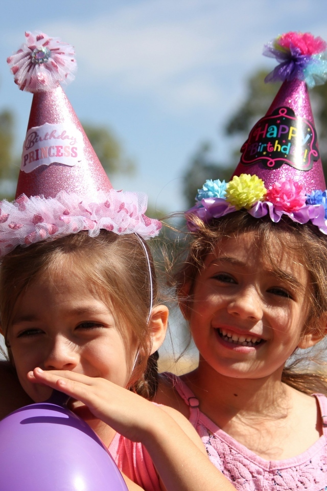 Две маленькие веселые девочки отмечают день рождения