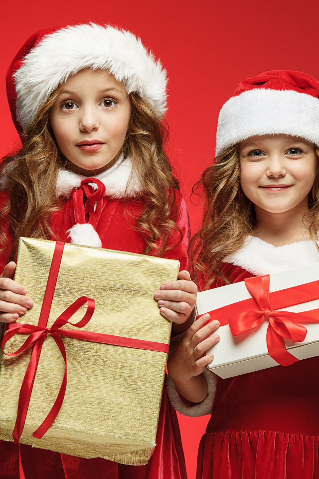Две маленькие девочки в новогодних костюмах с подарками