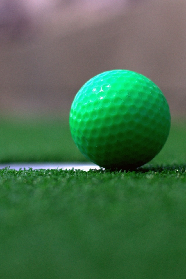 Зеленый мяч для игры в гольф на траве