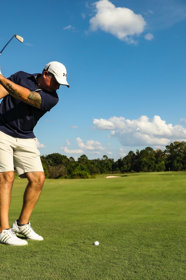 Мужчина занимается гольфом на поле