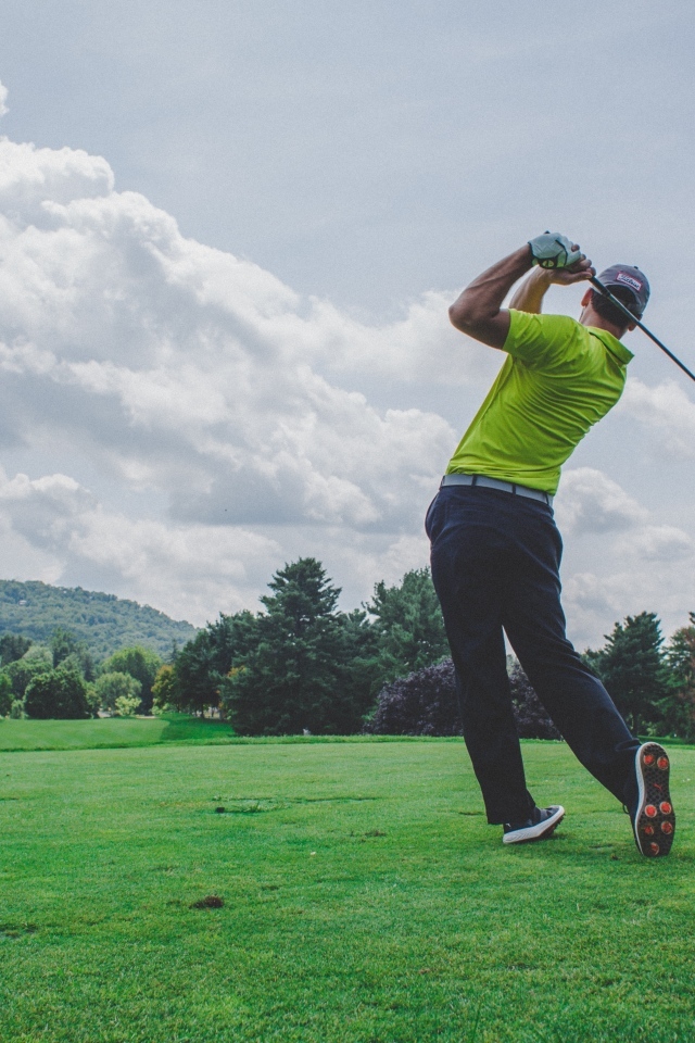 Мужчина играет в гольф на поле