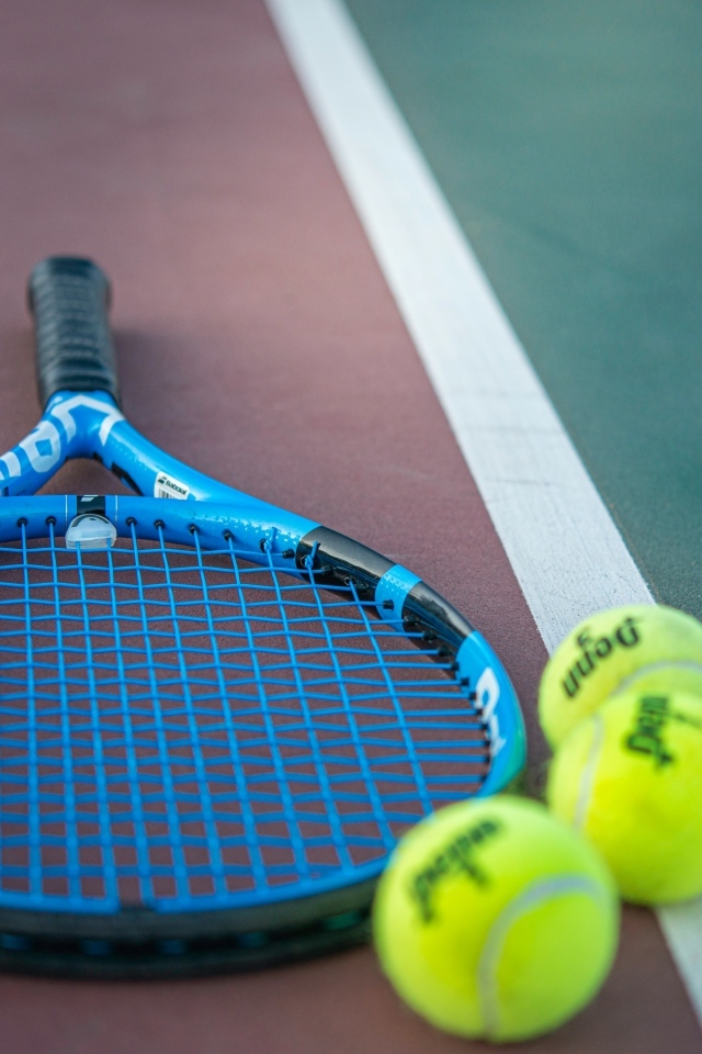 Ракетка и теннисные  мячи на корте