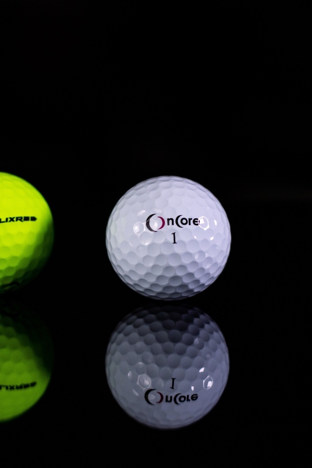 Два мяча для гольфа на черном фоне