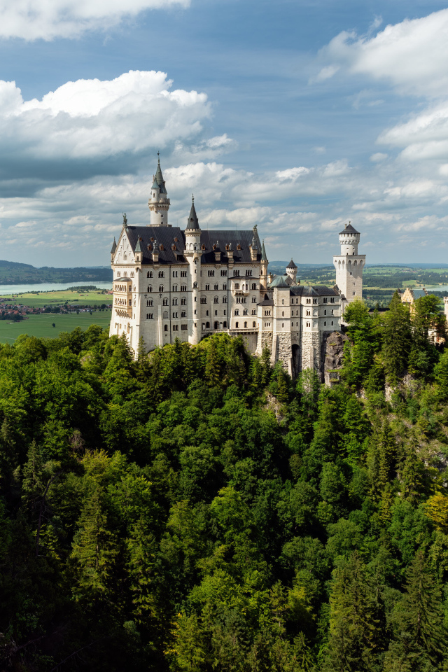 Замок Нойшванштайн в густых зарослях деревьев, Германия