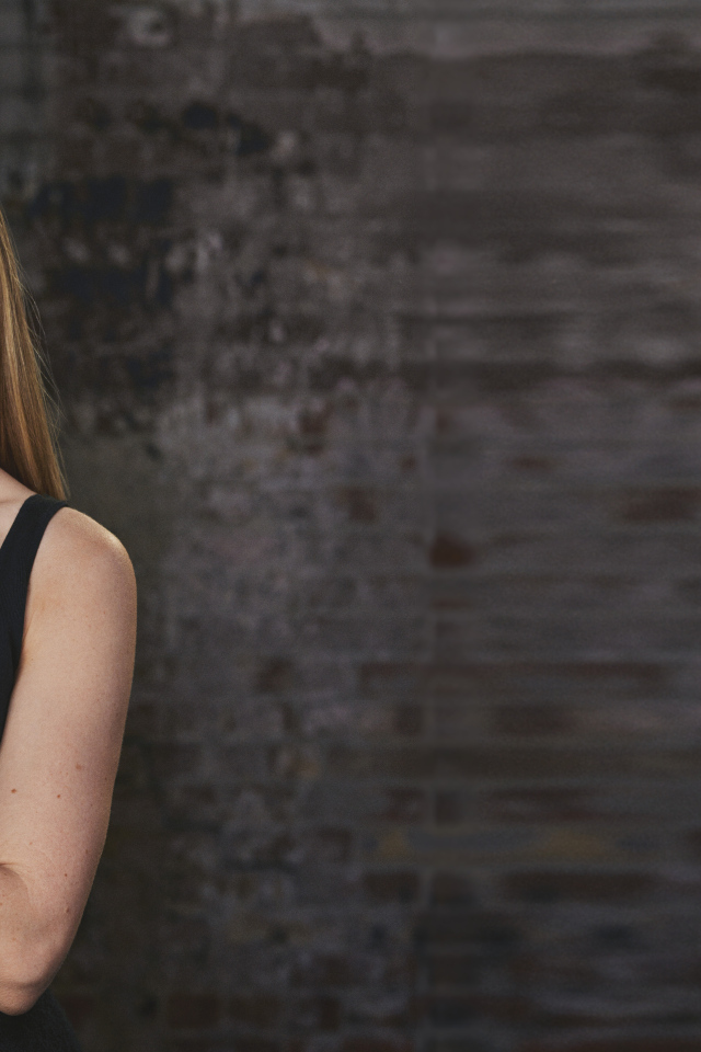 Актриса Аманда Сайфред на фоне кирпичной стены