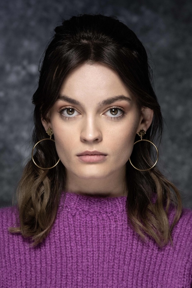 Актриса Эмма Маки на сером фоне