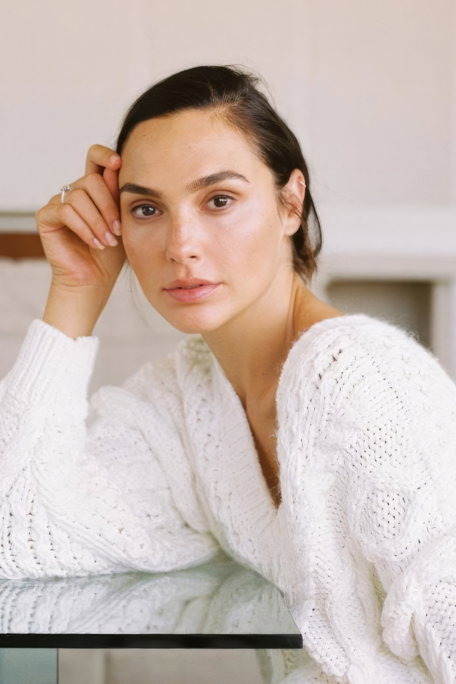 Актриса Галь Гадот в белом свитере за столом