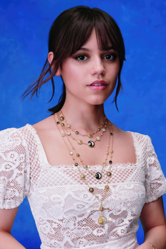 Актриса Дженна Ортега в белом платье на голубом фоне