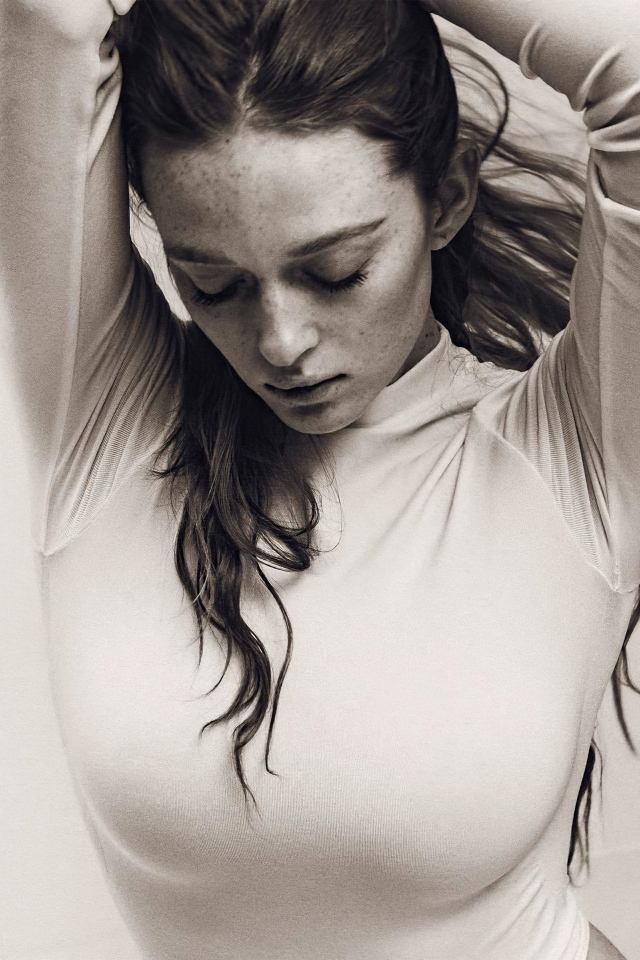 Актриса Ларсен Томпсон в белом боди на сером фоне