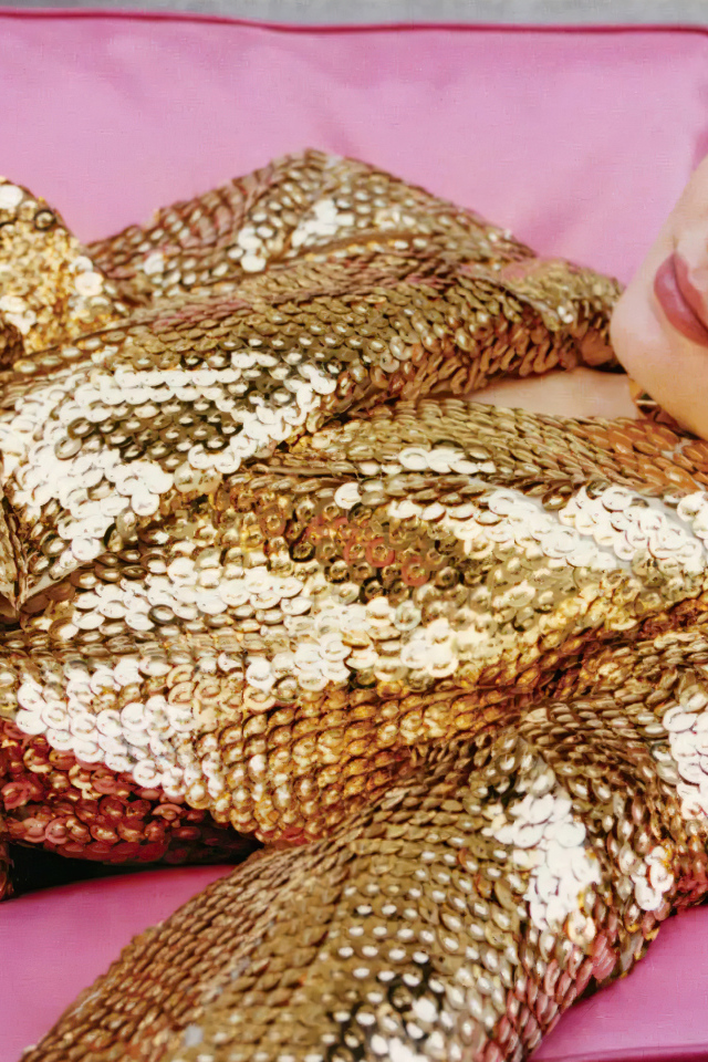 Актриса Сэди Синк в блестящем костюме на розовом диване