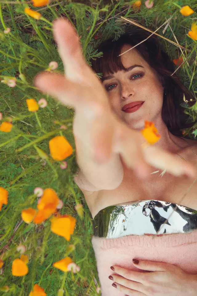 Американская актриса Дакота Джонсон лежит на траве с цветами