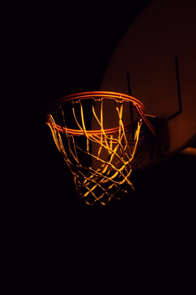 Баскетбольное кольцо в лучах света ночью