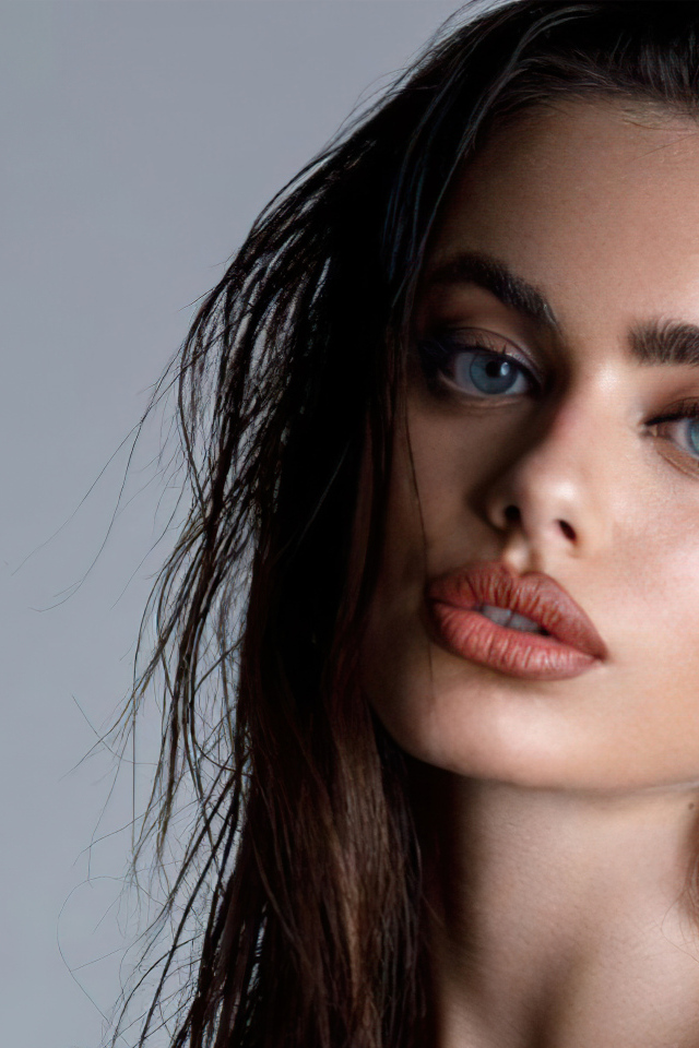 Красивая голубоглазая девушка Яэль Шелбиа на сером фоне