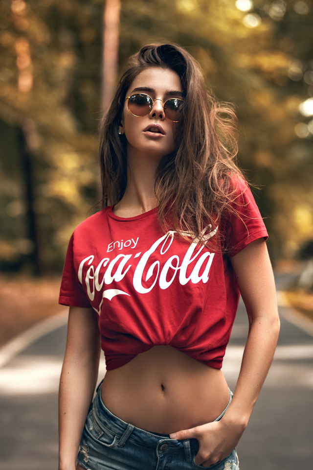 Красивая стройная девушка в футболке кока кола