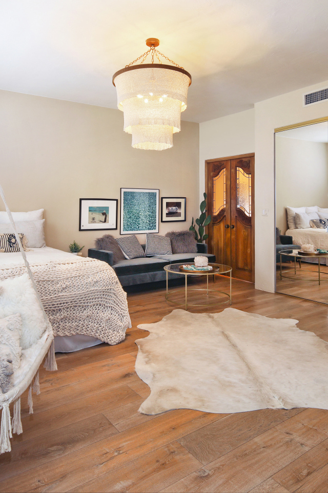 Спальня с белой кроватью и большим зеркалом